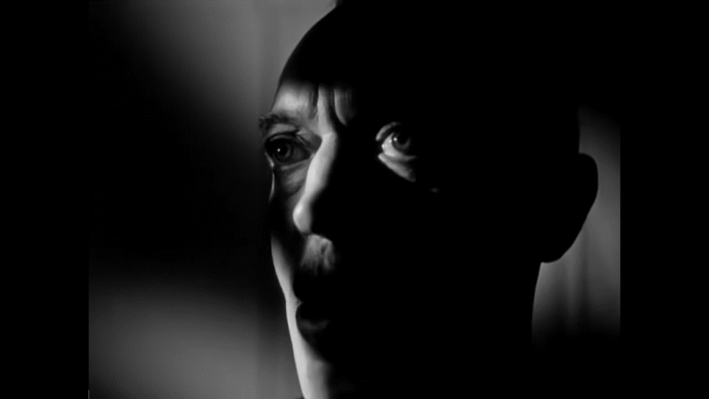 A close-up of a man's face, partially in shadow.
