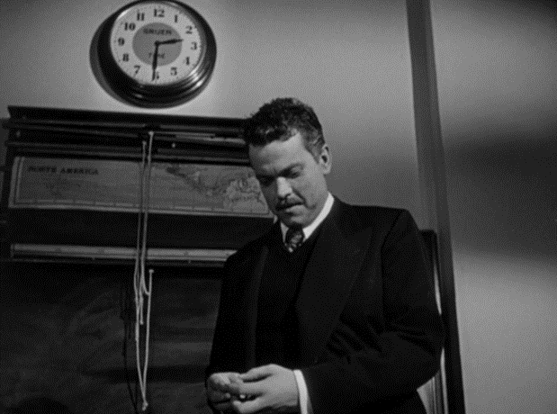 A medium angle shot of a man looking down at his watch.