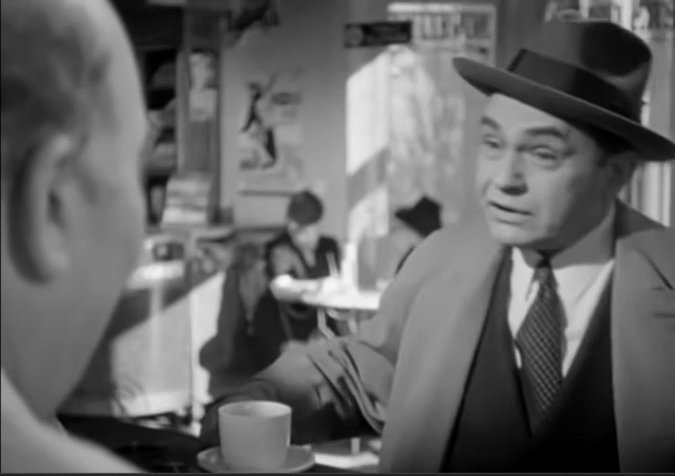 A shot looking over the shoulder of a man in the foreground at another man in the middle ground.